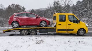 Czerwone auto na lawecie zimą – wymiana koła i pomoc drogowa Tczew